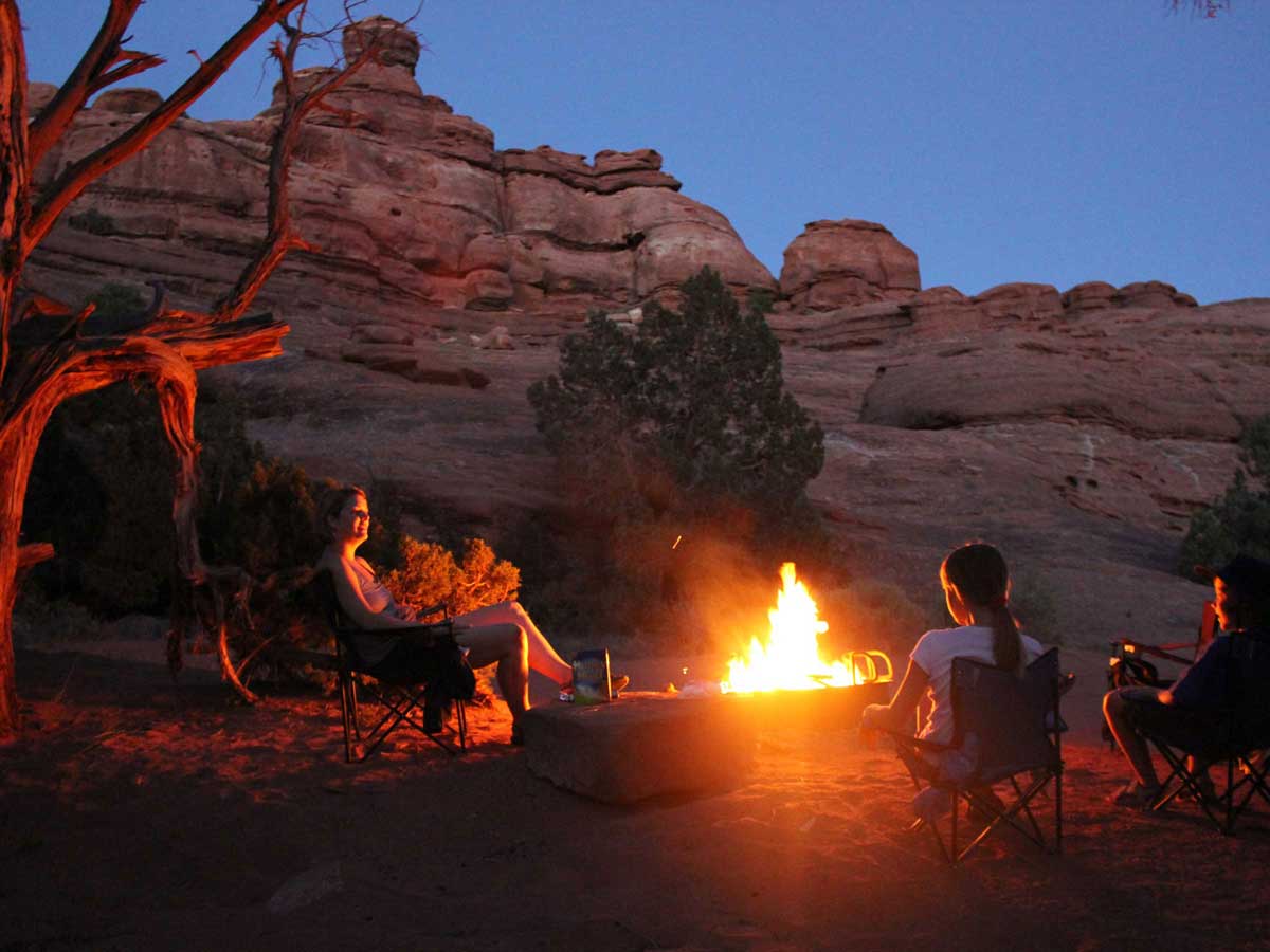 Family around fire at park near Gateway Canyons Resort