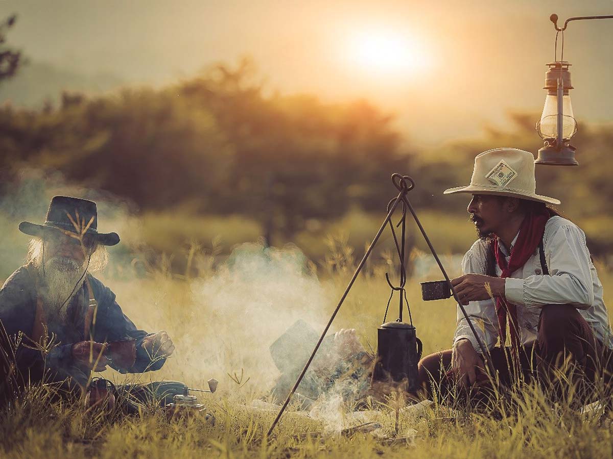 Two Guys Sitting By A Campfire.