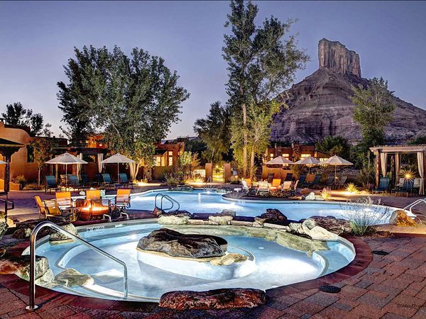 Outdoor pool and hot tub at dusk beneath the Palisade butte at Gateway Canyons Resort in Gateway, Colorado